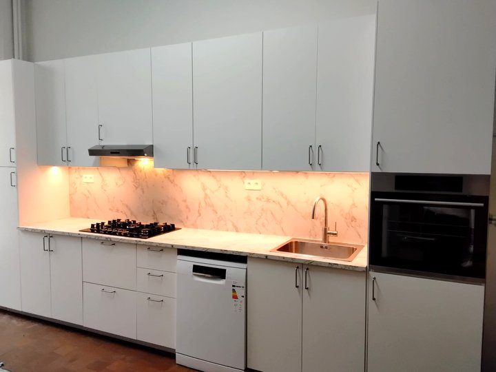 White kitchen with marble-look backsplash, built-in oven and under-cabinet lighting, by KALIX