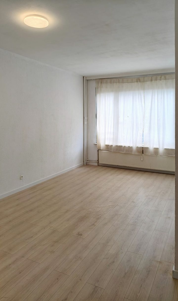 Renovated living room with laminate floor and large window