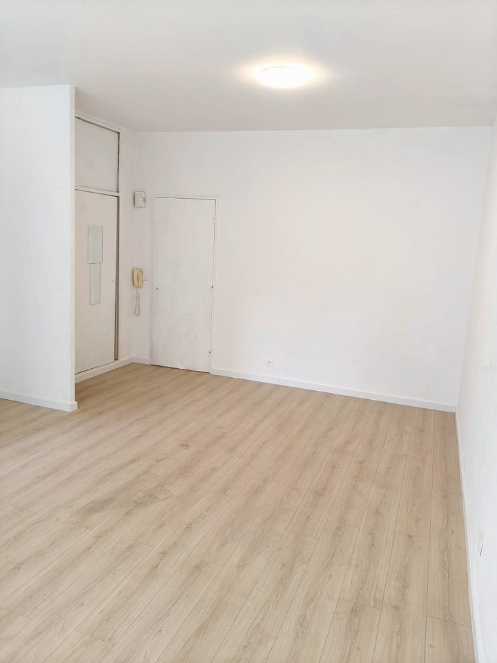 Renovated empty room with laminate floor and freshly painted walls