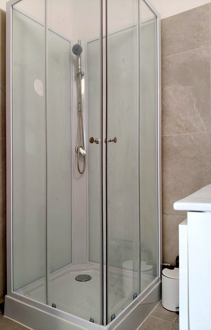 Renovated shower with glass cabin and wall tiles