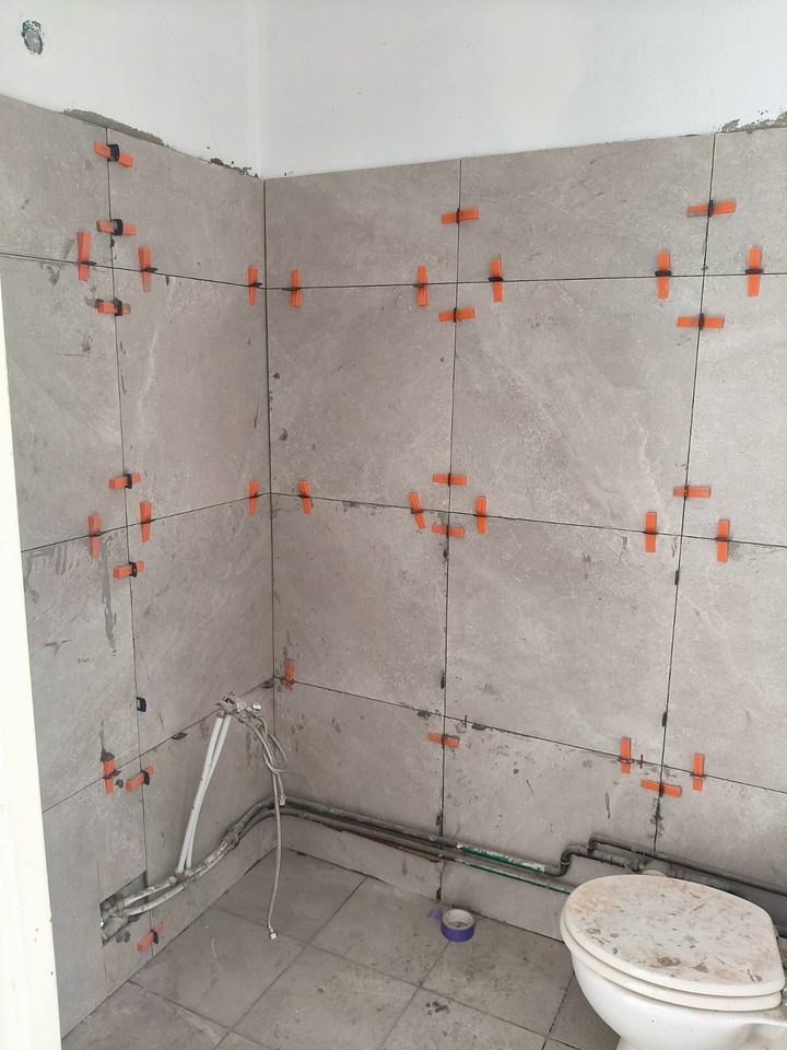 Wall and floor tiling in progress in a bathroom